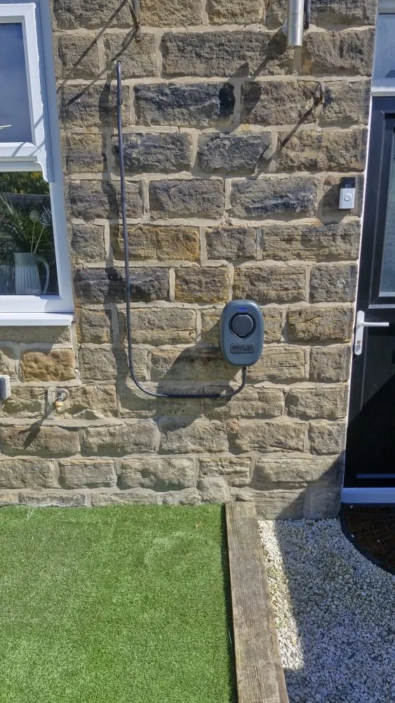 EV charger wall-mounted on a stone house with neat weatherproof cable routing in Wakefield by Knox Power & Data