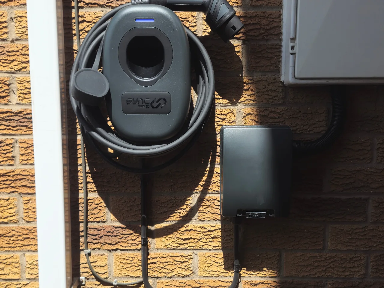 Sync EV tethered home charger fitted on a brick wall in Wakefield by Knox Power & Data, with weatherproof isolator
