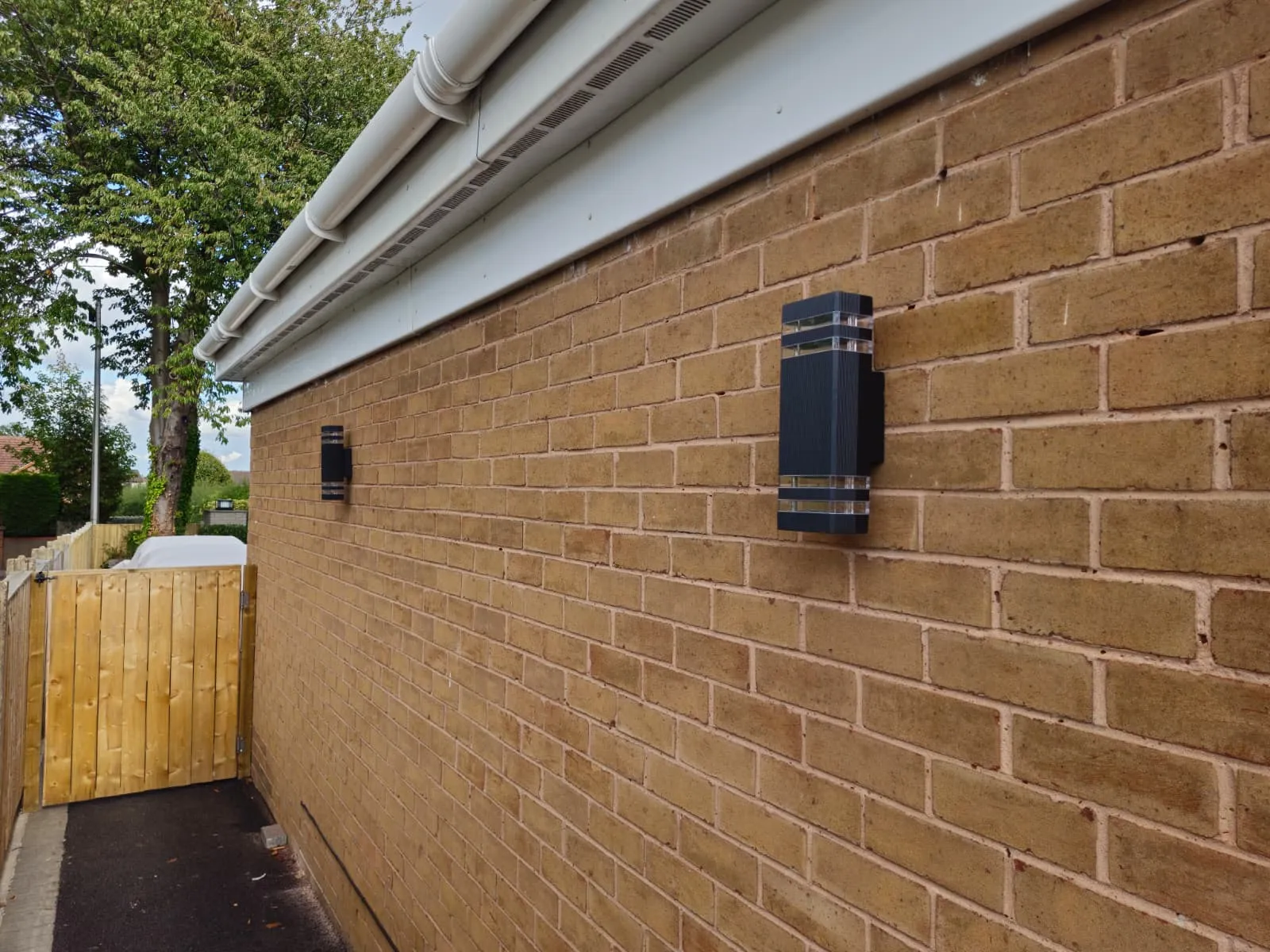 Outdoor light installation on brick wall in Wakefield